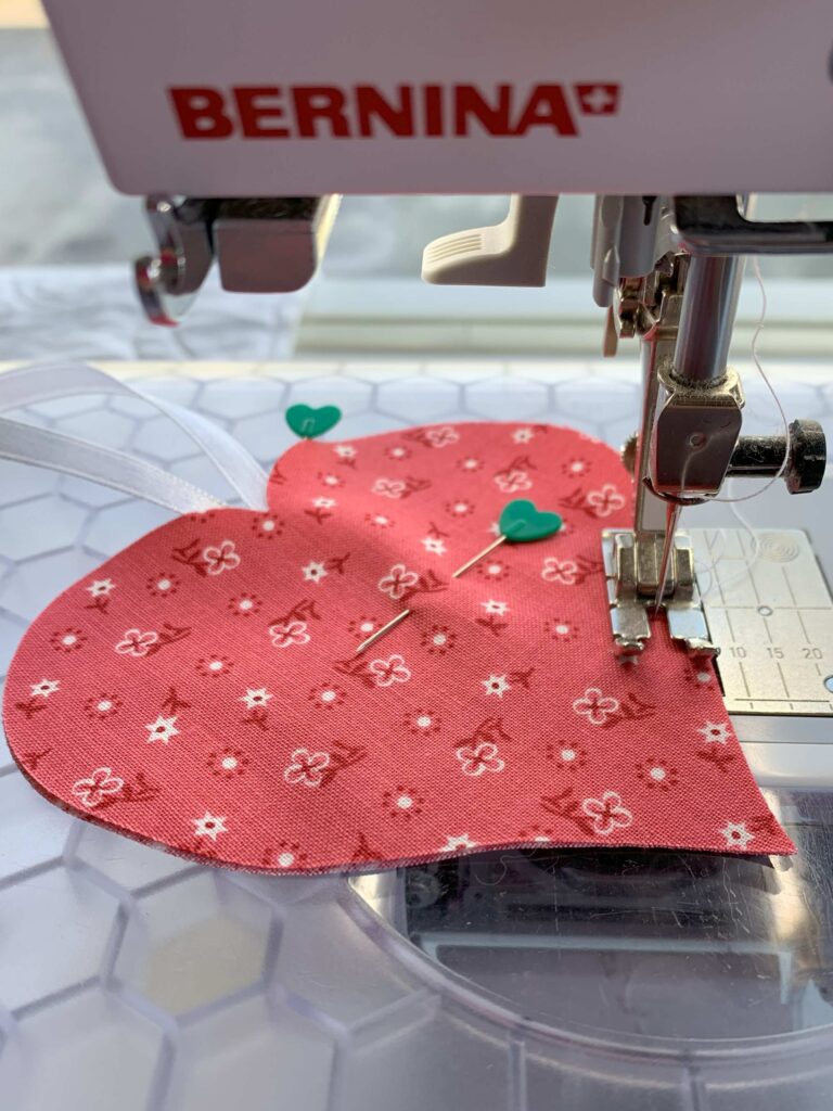 Sewing two pieces of heart fabric together on Bernina sewing machine Step 4 in How to Make an Easy Lavender Heart Sachet ~ Tutorial #lavender #lavenderflowers #lavendersachet #lavendersachets #diylavendersachet #lavendersachettutorial #lavendersachetbags #sewlavendersachet #diytutorial #sewingtutorial #diygifts 