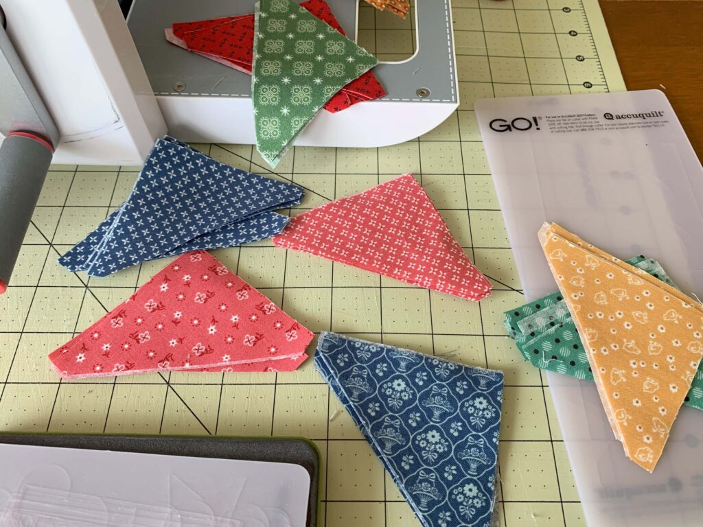 Using Go! Baby from Accuquilt to cut out fabric for our new block of the month.  #accuquilt #go!baby #halfsquaretriangles #2024blockofthemonth #2024bom