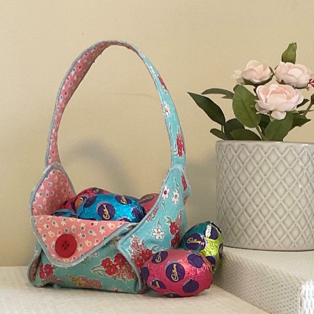 Pretty fabric basket with Easter eggs inside and around it