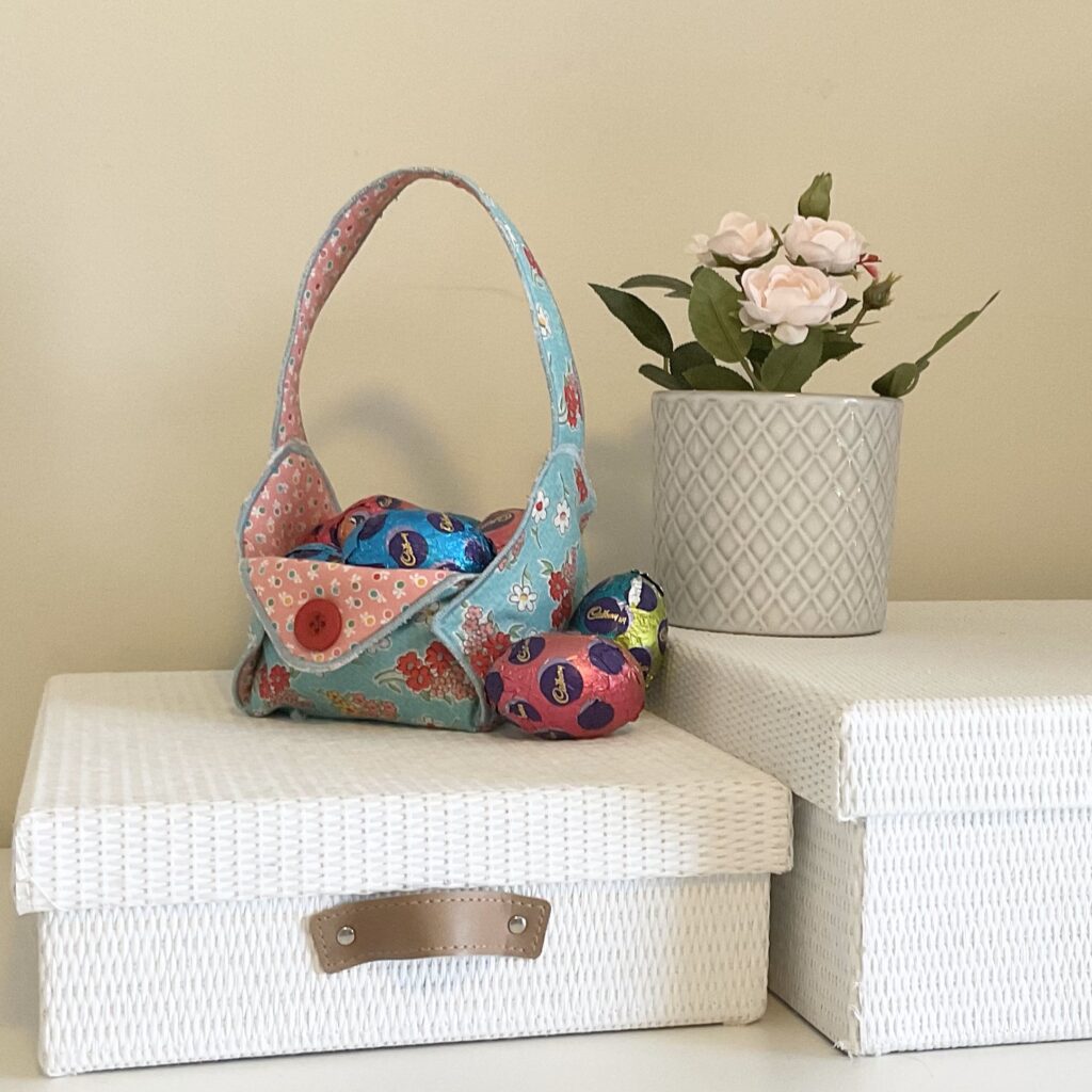 Pretty fabric basket with Easter eggs inside and around it