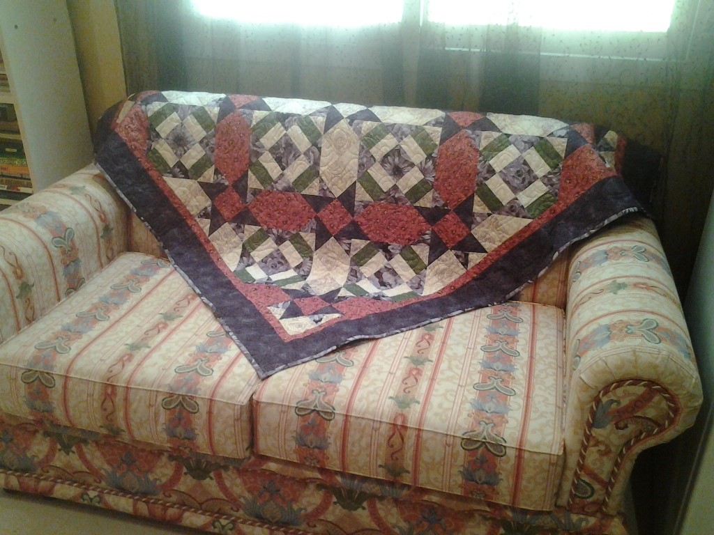 purple quilt draped on couch