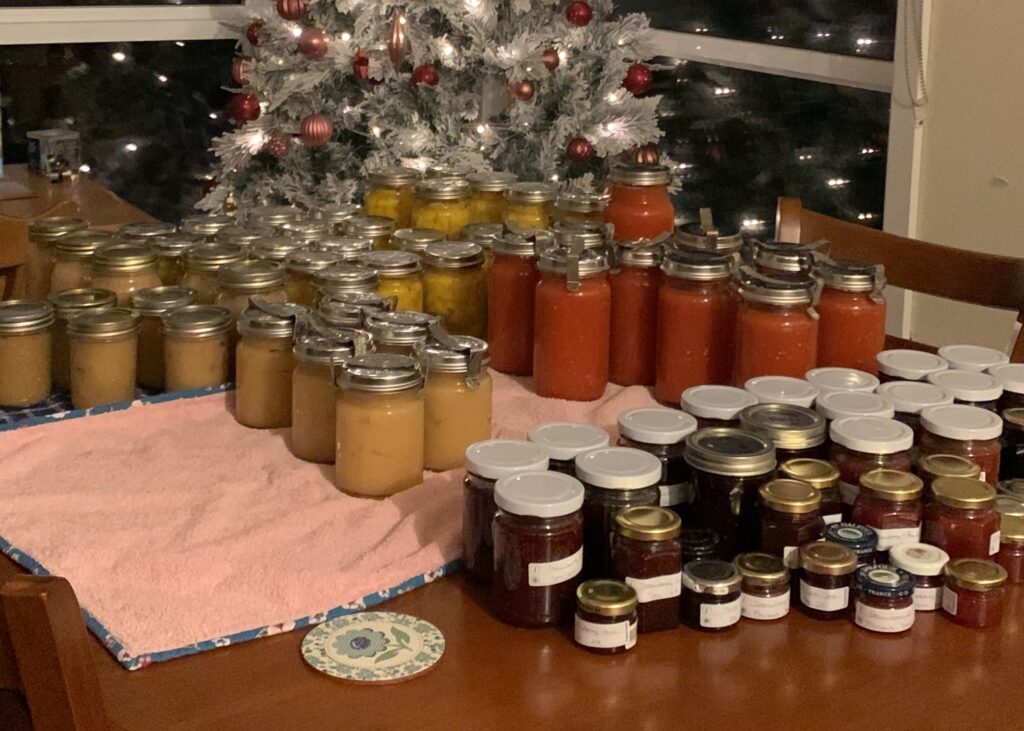 Bottles of homegrown and home made canned fruit, tomatoes, jams and relishes